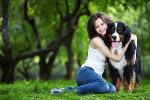 Jeune femme serrant son chien dans ces bras